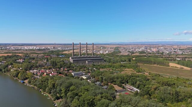 Tiszapalkonya, Hungary decommissioned coal-fired power plant with smokestacks beside the Tisza River, industrial landscape and forest in summer, viewed by drone.