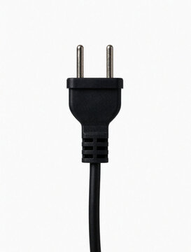 Black electrical plug with two prongs and cord against clean white background. Minimal still life composition focuses on power connector detail and utility. Simple design element for tech concepts.