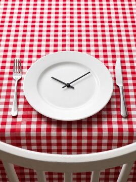 Time management concept with clock hands on a dinner plate