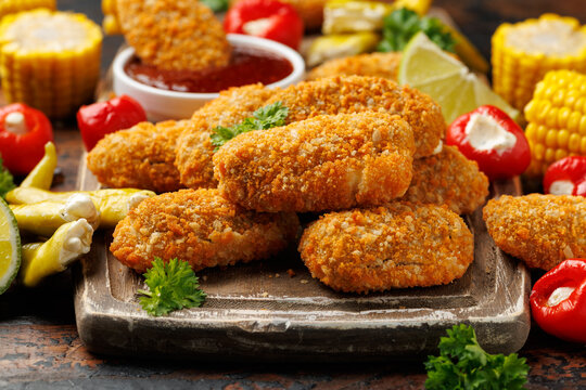 Crispy baked cream cheese stuffed jalapeno poppers with lime wedges and sweet chili sauce