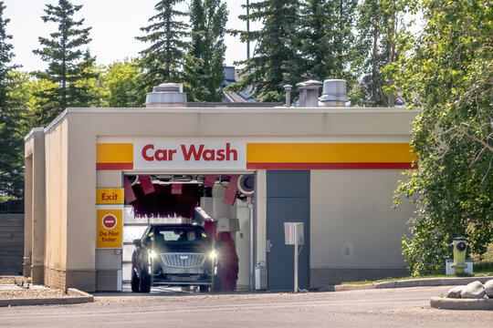 Calgary, AB, Canada - Sept 14, 2026: Modern automated car wash facility bay with a vehicle exiting the washing bay outdoors.