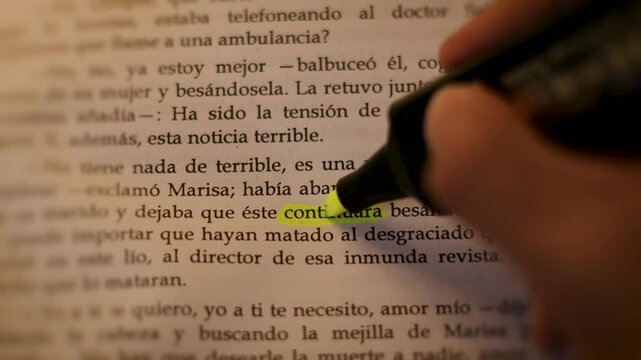 Macro detail of a hand using a yellow highlighter on the word 'continuara' in a Spanish book under cinematic low-light.