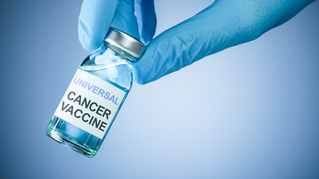 Nurses hand in blue medical gloves holding a vaccine bottle with Universal Cancer Vaccine text. Health care concept of comprehensive vaccines for prevention or treatment of various cancers.