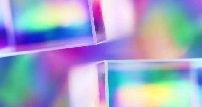 Light reflecting glass in brilliant saturated colors. Radiant lighting through a prism creating a visual of a rainbow effect of colorful light refraction. Spinning geometric cube abstract background.