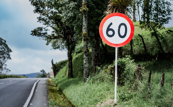 Se&ntilde;al de l&iacute;mite de velocidad de 60 km/h en carretera rural rodeada de vegetaci&oacute;n