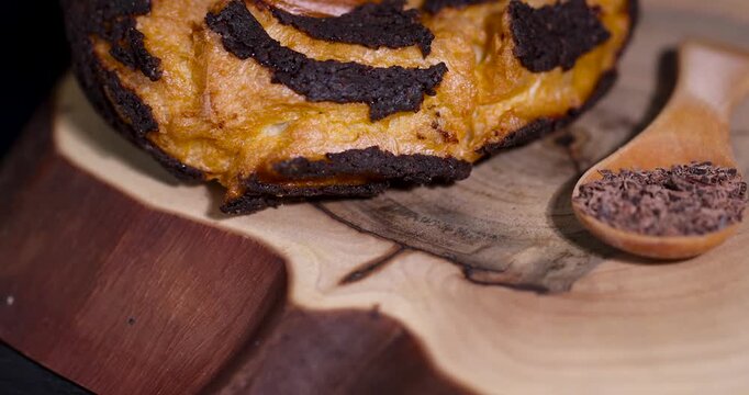 Sweet cookies dessert with chocolate glaze stripes, single baked shortbread cookie pastry resting on wood stump log platter