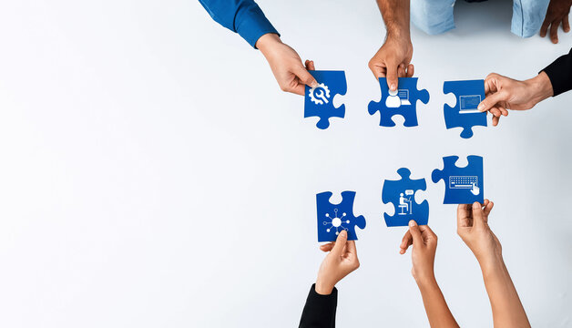 A diverse group of hands working together to assemble blue puzzle pieces, symbolizing collaboration, creativity, and innovative problem-solving in a modern workspace. Amity