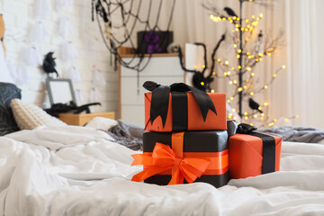 Naklejka premium Halloween celebration and gift giving, orange and black presents on a bed in a decorated room with festive lights and spooky holiday home decor