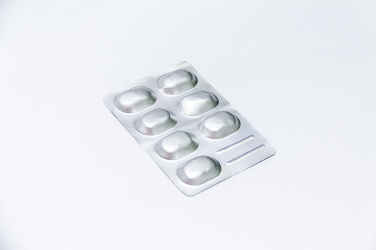 Seven white tablets sealed in a silver blister pack on a clean white background
