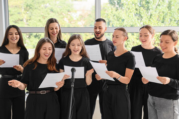 Choir performance and team collaboration, diverse group of singers practicing music with sheet...
