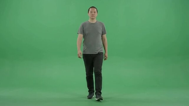 Adult male walking in place against green screen chroma key background