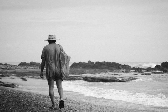 Portrait of a fisher man walking alongside of the beach in black and white