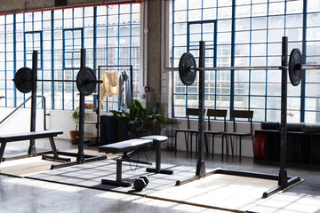Obraz premium Center weight setup occupying space with bench and loaded barbells on lifting platform in warehouse