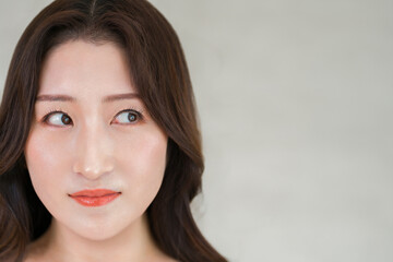 Fototapeta premium 透明感のある美肌と目元が印象的な若い女性。アイケアと美容のイメージ