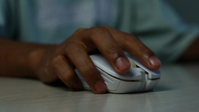 Hand Using a White Computer Mouse, Close-up of a dark-skinned hand using a white computer mouse on a desk, showing online work, browsing, gaming, and everyday technology.