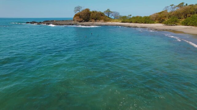 Calm turquoise bay with rocky edges and sandy Pitahaya beach in Costa Rica