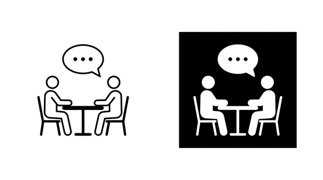 Two people talking at a meeting table