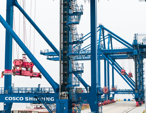 COSCO Shipping cranes handle containers on river barges at Wuhan rail-water intermodal base, a vital logistics hub featuring a smart terminal for intelligent transport. Wuhan, China, 11 Oct 2025