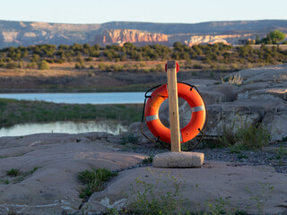 Orange life ring stands by rocky shore at Abiquiu Reservoir, New Mexico. © missy_photos