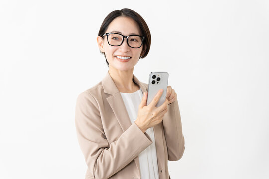 スマトフォンを使う眼鏡をかけたスーツ姿の女性