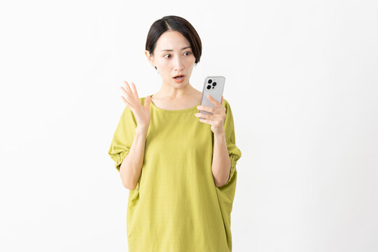 スマートフォンを使うカットソー姿の女性　ライフスタイルイメージ