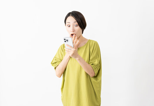 スマートフォンを使うカットソー姿の女性　ライフスタイルイメージ