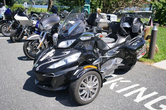 Havre de Grace, Maryland, U.S.A - Aug 29, 2026 - Three-wheeled Can-Am Spyder parked with multiple motorcycle on the asphalt road