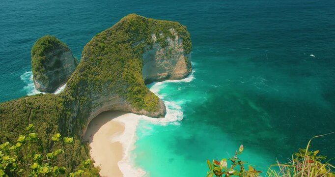 Nusa Penida Island Bali features Kelingking Beach with iconic rock formation and blue ocean waves