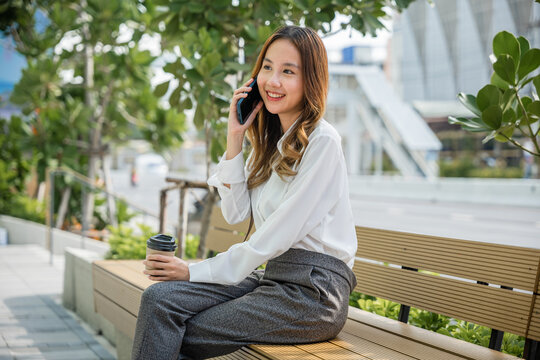 woman using mobile smartphone talking on cellphone outdoor corporate building exterior