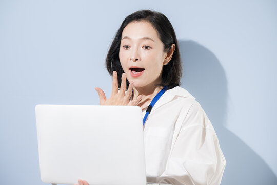 ノートパソコンを見ながらビックリする驚く困る表情をする女性会社員、仕事の問題やミス、トラブルやストレスに悩む日本人ビジネスウーマンクローズアップ