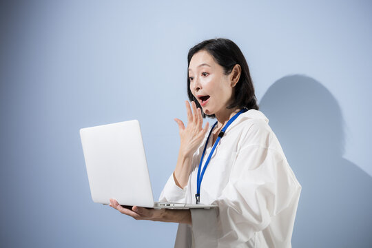 ノートパソコンを見ながらビックリする驚く困る表情をする女性会社員、仕事の問題やミス、トラブルやストレスに悩む日本人ビジネスウーマンクローズアップ