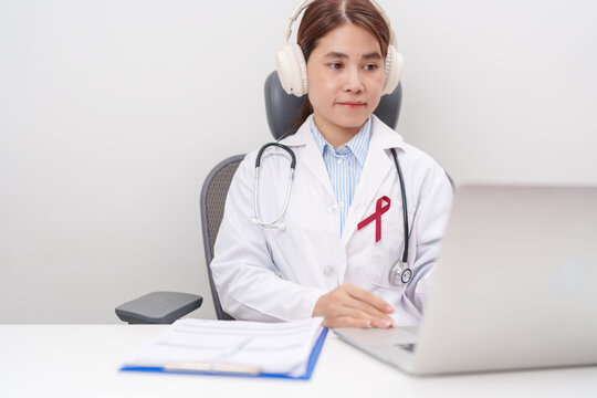 doctor using laptop for telehealth, online consultation and meeting about burgundy ribbon concept of March Multiple Myeloma Cancer Awareness month, September Sickle Cell Anemia, Headache and Migraine