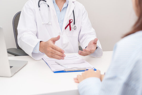 Doctor and patient having a medical consultation for burgundy ribbon concept of March Multiple Myeloma Cancer Awareness month, September Sickle Cell Anemia, Headache and Migraine week
