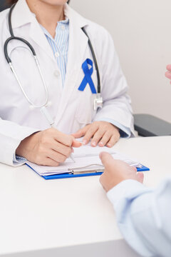 Doctor and patient having a medical consultation for Navy blue ribbon concept of March Colorectal and Colon Cancer Awareness month, May Arthritis awareness, July Juvenile arthritis and Childhood