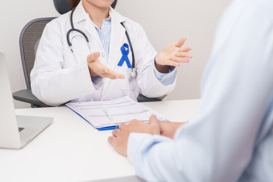 Doctor and patient having a medical consultation for Navy blue ribbon concept of March Colorectal and Colon Cancer Awareness month, May Arthritis awareness, July Juvenile arthritis and Childhood