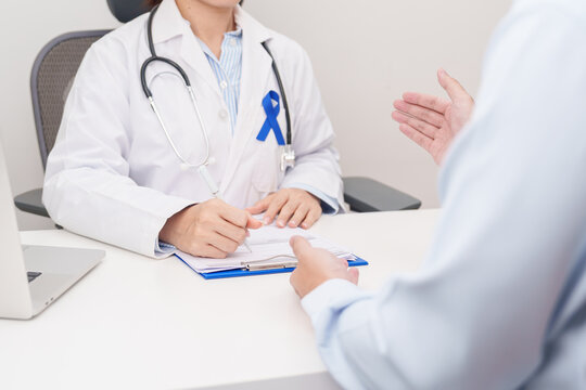 Doctor and patient having a medical consultation for Navy blue ribbon concept of March Colorectal and Colon Cancer Awareness month, May Arthritis awareness, July Juvenile arthritis and Childhood