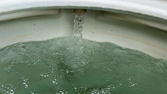 Water flowing into a toilet bowl cistern
