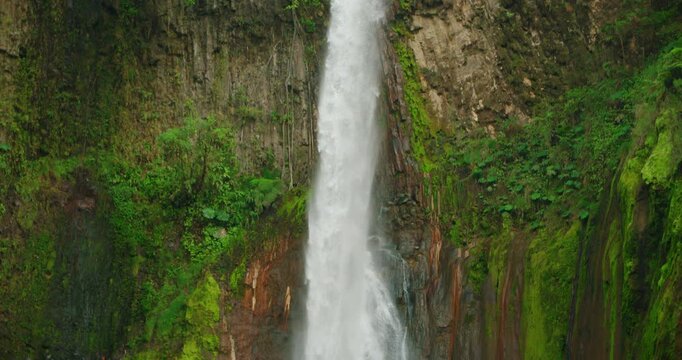 Majestic Blue Falls waterfall dropping down steep cliff surrounded by Costa Rica greenery