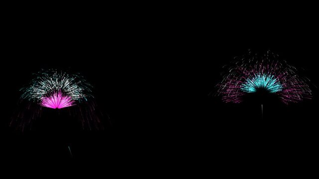 Alternating cyan and magenta fans launch diagonally across the sky with a side tracking camera. Ten second seamless animation for New Year greetings, midnight parties and festive holiday titles.
