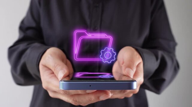 File management. Professional businesswoman holding her mobile phone, and a virtual icon of a folder and a gear.