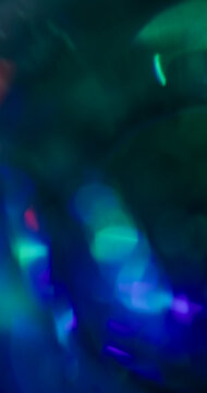 Defocused shiny reflection. Luminous glow. Blur blue green radiant optical texture gradient visual glint on abstract art illuminated bokeh background.