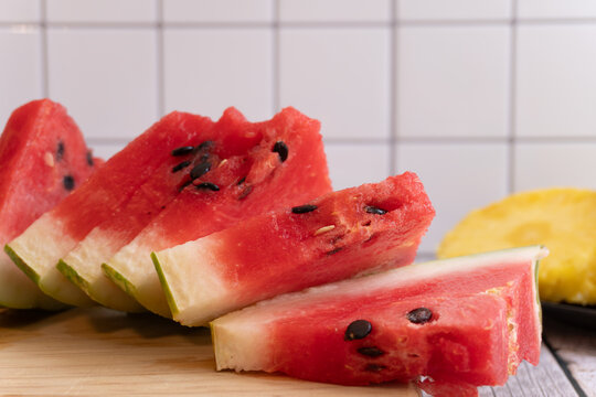 Fresh watermelon slices rest on a wooden board