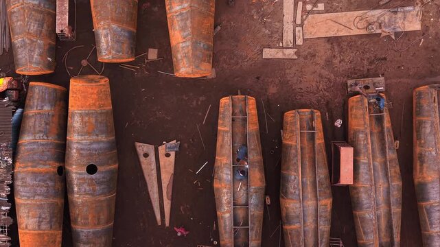 Rows of large rusty steel storage tanks at industrial tank manufacturing fabrication yard