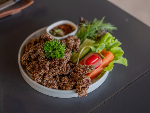 Thai crispy fried pork chunks coated with toasted rice and herbs or Moo Kluk Foon
