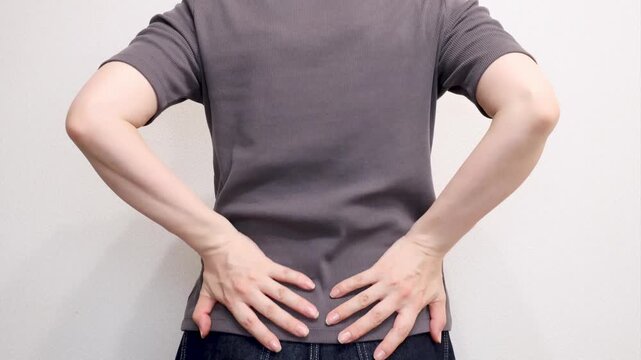 両手を腰に当てる女性の後ろ姿