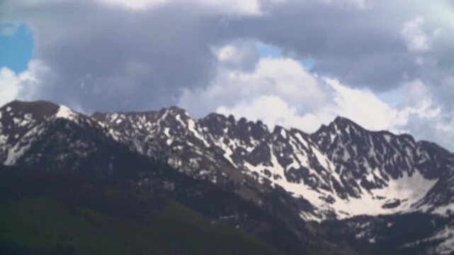 Slow motion wide shot of BMX rider doing 360 in the snowy mountains