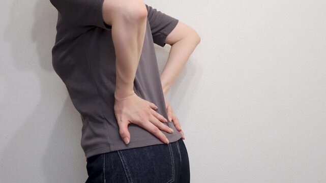両手を腰に当てる女性の後ろ姿