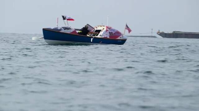 Wide shot of woman rowing small boat in the ocean