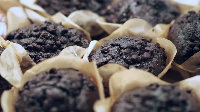 People are preparing chocolate muffins with care in a cozy kitchen