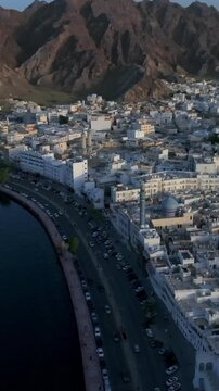 Vertical Aerial Evening View of Mutrah Corniche Muscat Oman with Hajar Mountains